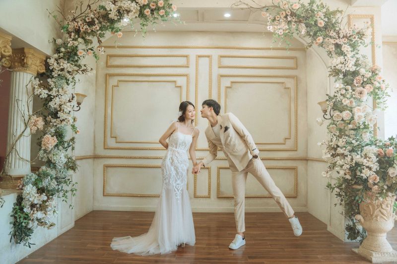 Chụp ảnh cưới chú rể hôn má cô dâu