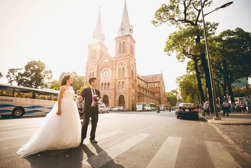 chú rể dăt tay cô dâu ở khung cảnh chỗ nhà thờ đức bà