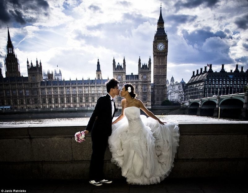 chú rể hôn cô dâu phá sau lưng la toà tháp lớn