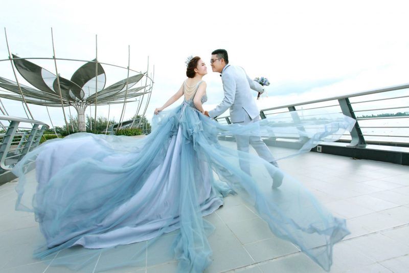 cô dâu mặc váy xoè màu xanh nước biển nhạt cùng chú rể mặc vest màu xanh