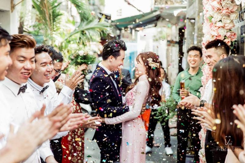 co dâu và chú rể đang ôm nhau có pháo hoa giấy nổ tung toé