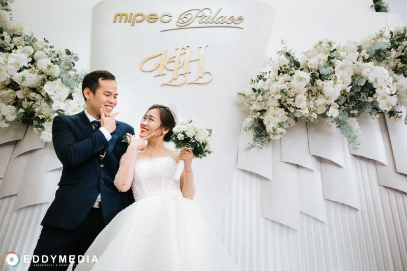 chú rể và cô dâu chụp hình ở tường trang trí