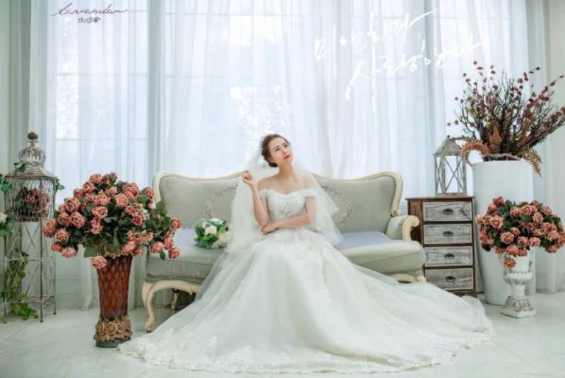 cô dâu ngồi tạo dáng trên ghế sofa màu trắng