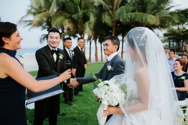 chú rể bắt tay người đàn ông mặc áo vest đen