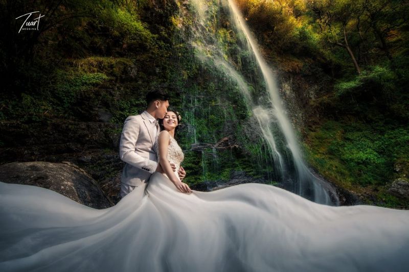 chú rể ôm cô dâu bên dòng thác chảy