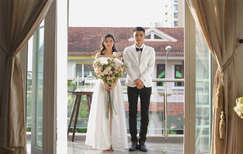 cô dâu chú rể đứng cạnh nhau tạo dáng