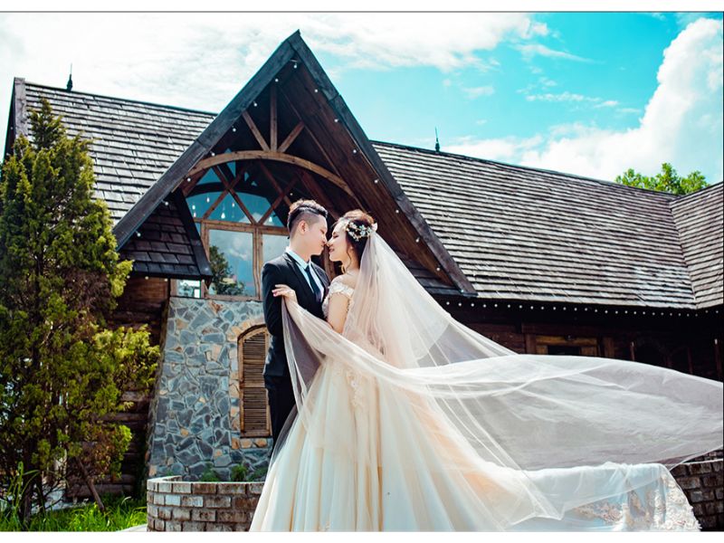 cô dâu chú rẻ ôm nhau trước ngôi nhà