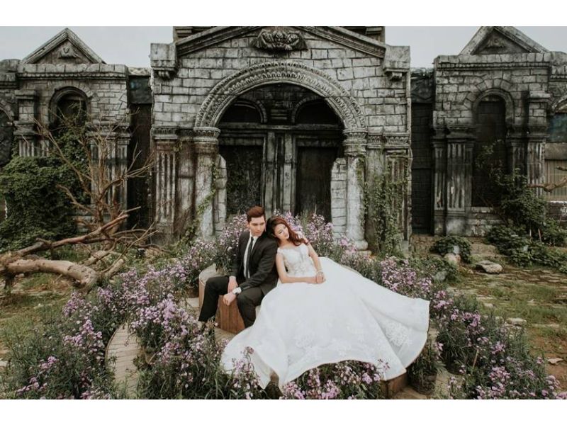 cô dâu cùng chú rể nằm cạnh nhau trước ngôi nhà