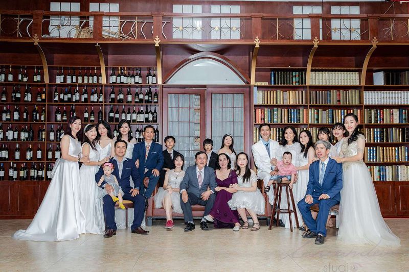 dịch vụ chụp ảnh gia đình tại phim trường Huế chụp ảnh gia đình cùng nhau đứng trước tủ sách lớn