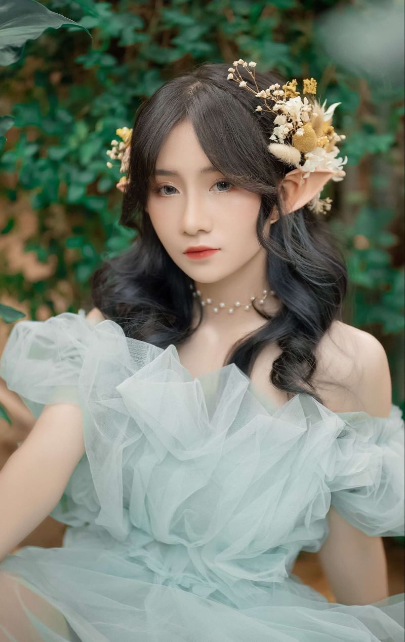 cô gái mặc váy xanh gắn hoa đầy đầu