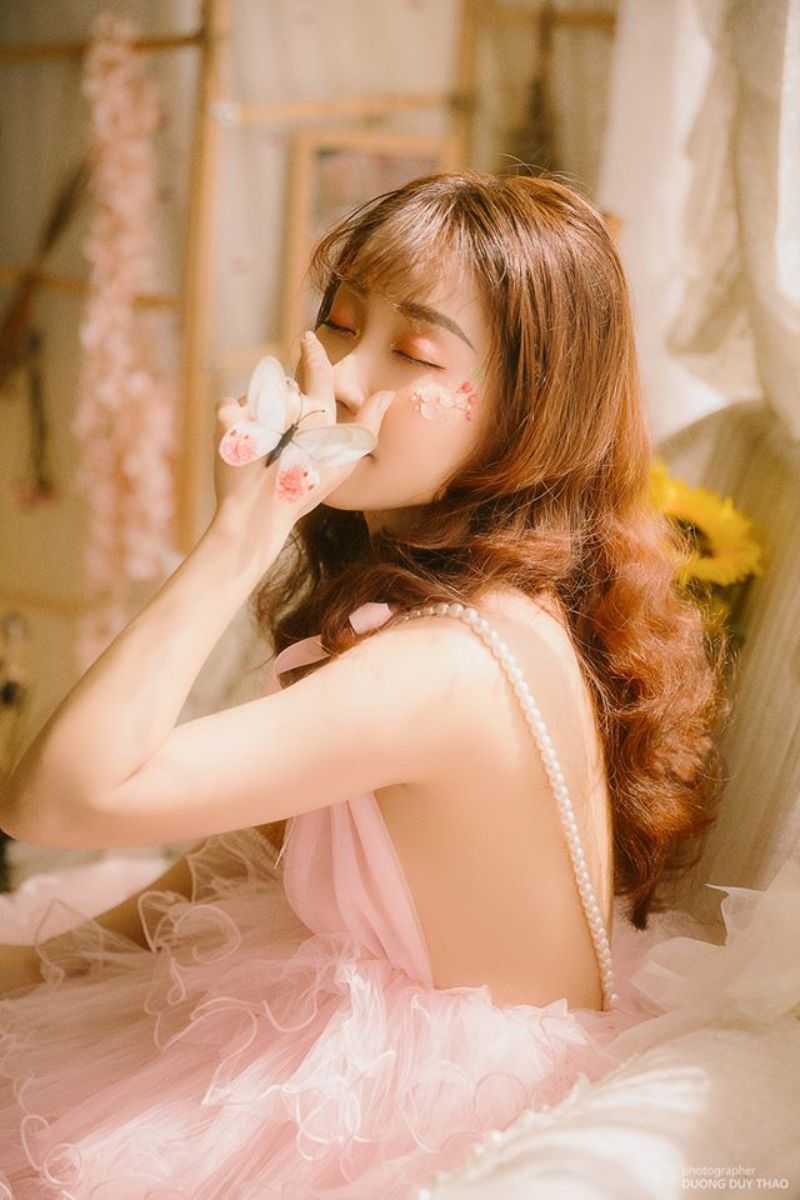 cô gái mặc váy hồng lấy tay che mặt