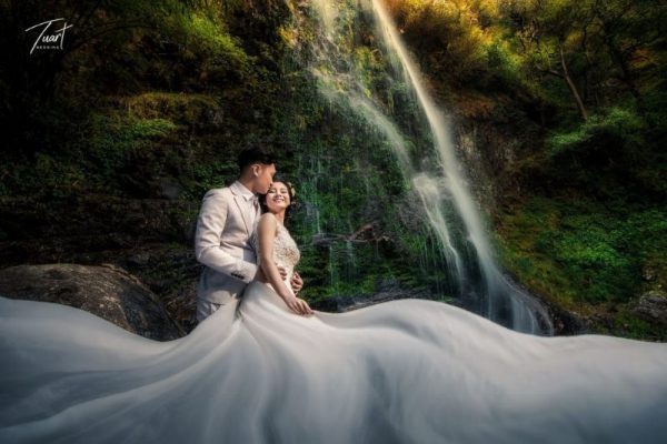 chú rể ôm cô dâu bên dòng thác chảy