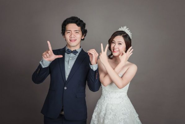 cô dâu và chú rể giơ tay say hi với máy quay phim